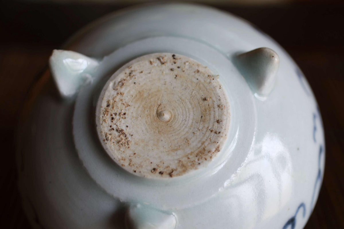 A close-up view of the bottom of a white ceramic bowl with a circular design on the surface.