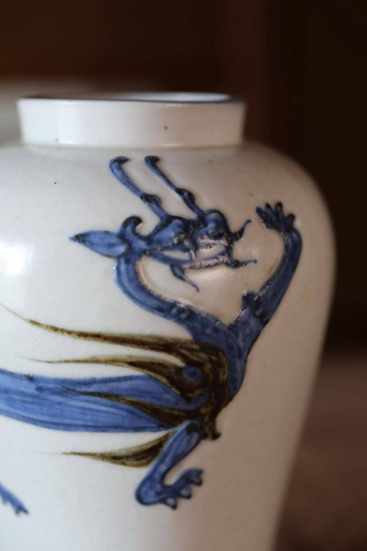 A close-up image of a white vase with a blue dragon design on it.