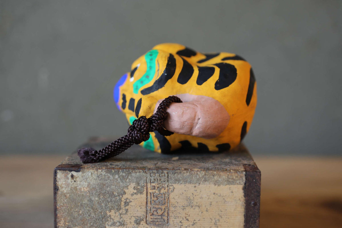 A colorful, abstract sculpture resembling a fish or sea creature is displayed on a wooden surface.