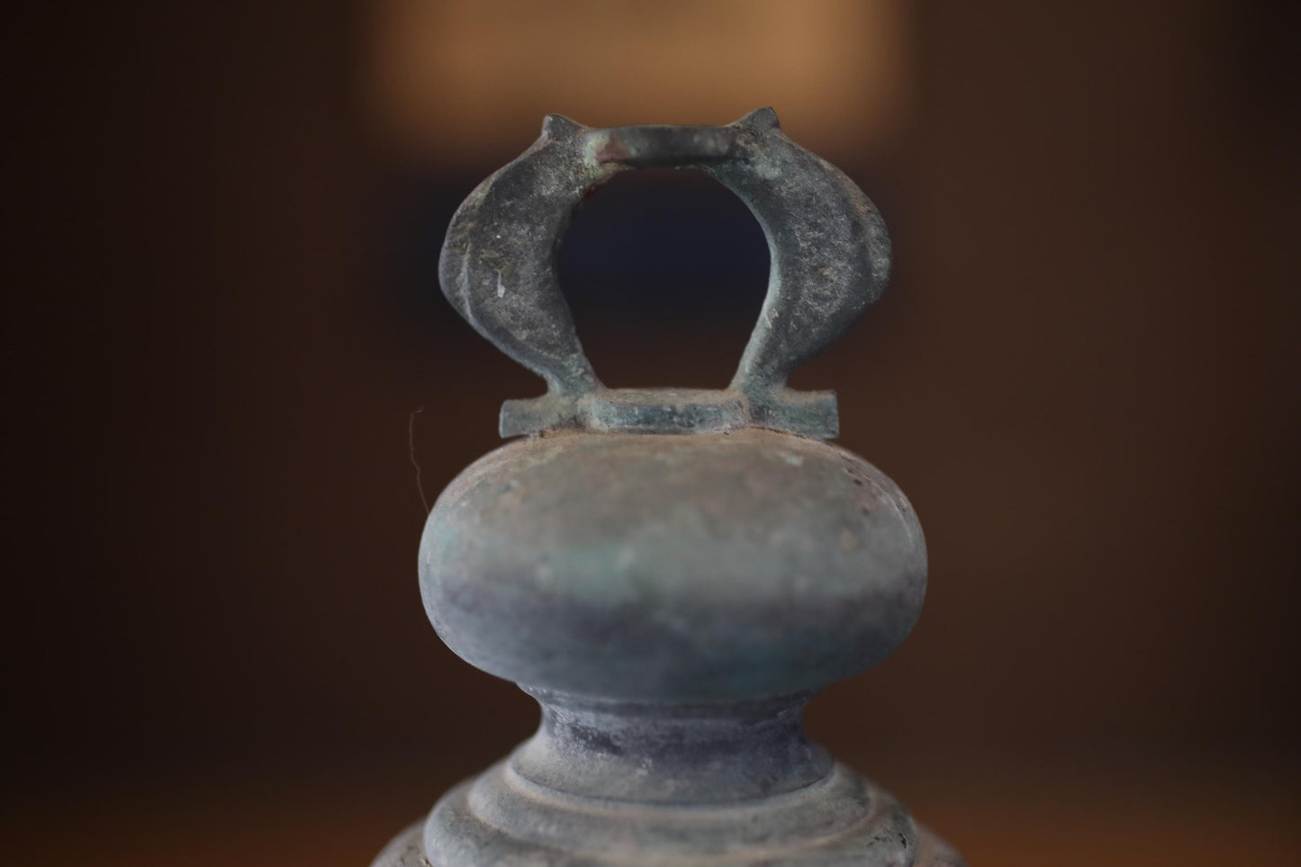A close-up view of an old, weathered metal object with a distinctive, curved shape.