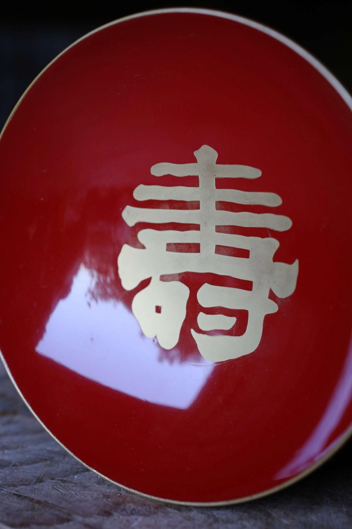 A close-up image of a red plate with a gold Chinese character on it.