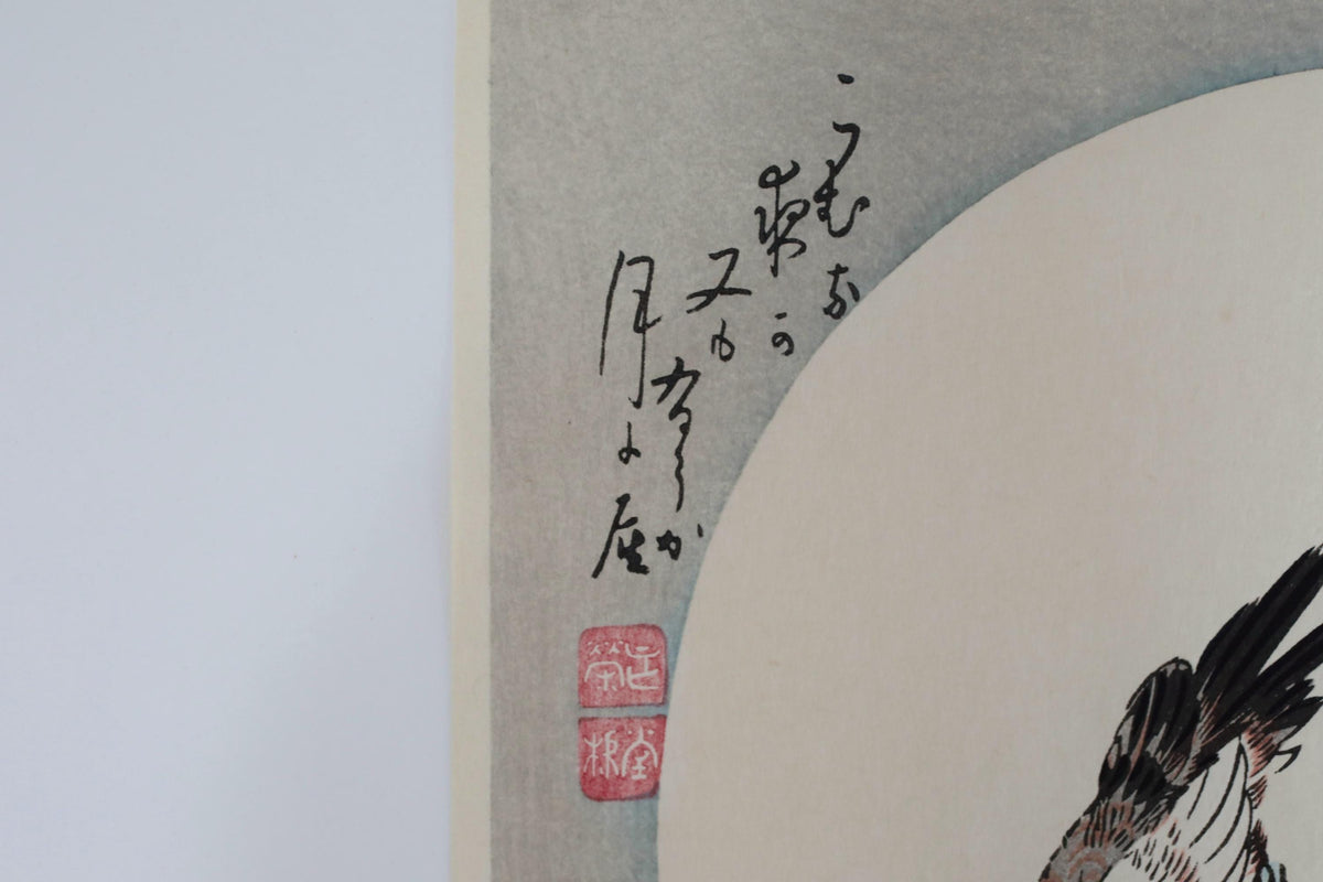 a close-up view of a piece of artwork with Japanese calligraphy and a bird illustration. The artwork appears to be a watercolor painting, with the bird depicted in a detailed manner. The calligraphy on the artwork is in Japanese, adding a cultural element to the piece.