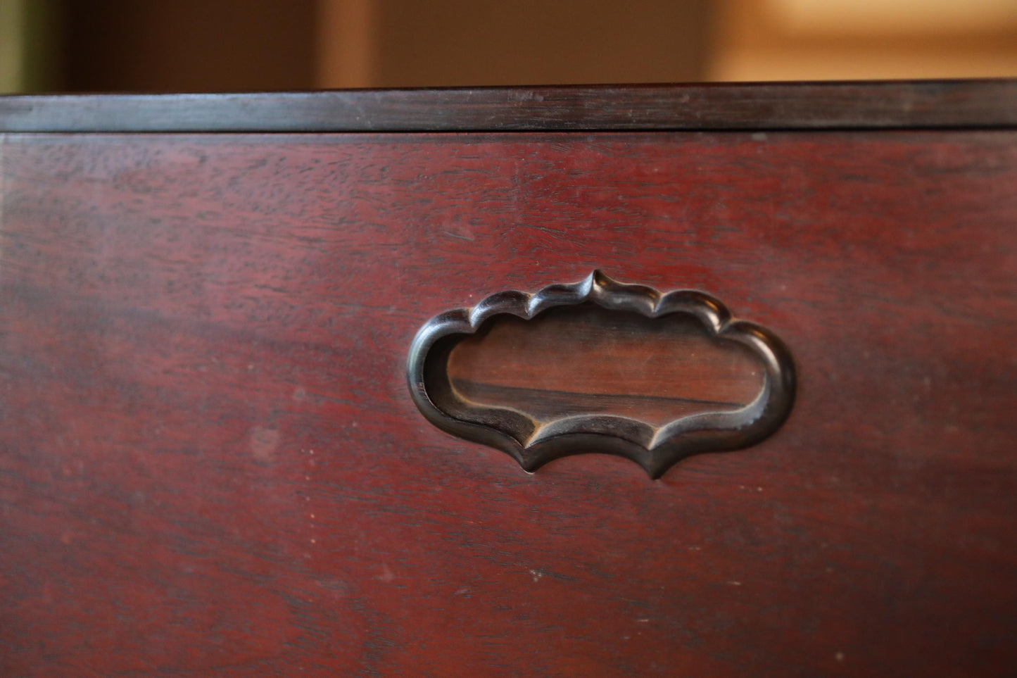 a close-up view of a wooden surface with a decorative metal handle or knob in the center.