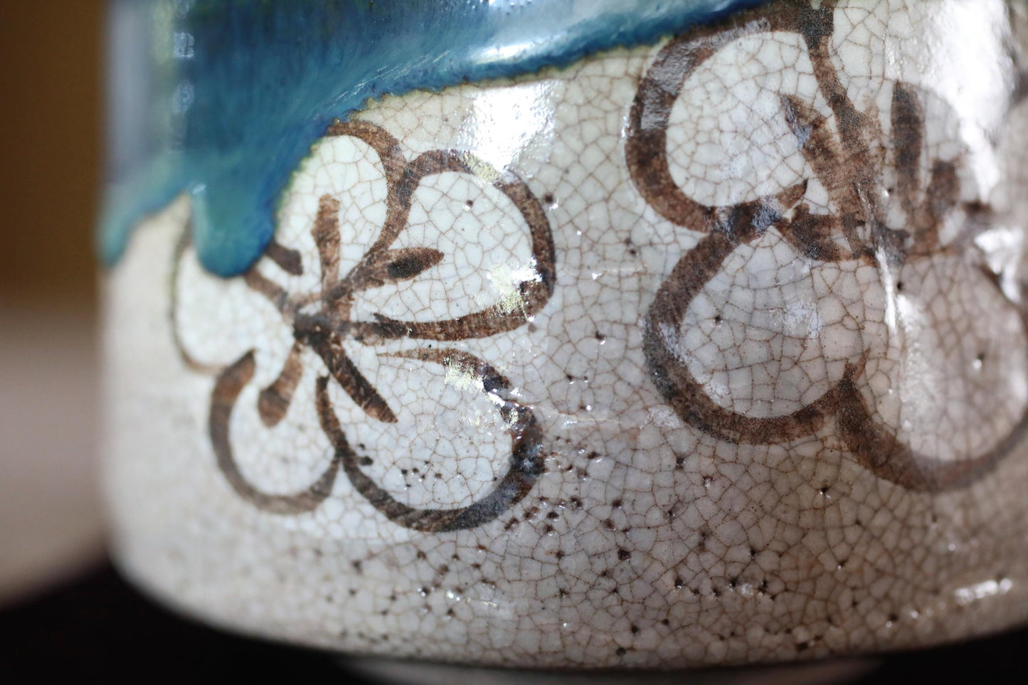A close-up image of a ceramic vase with a floral pattern on its surface.