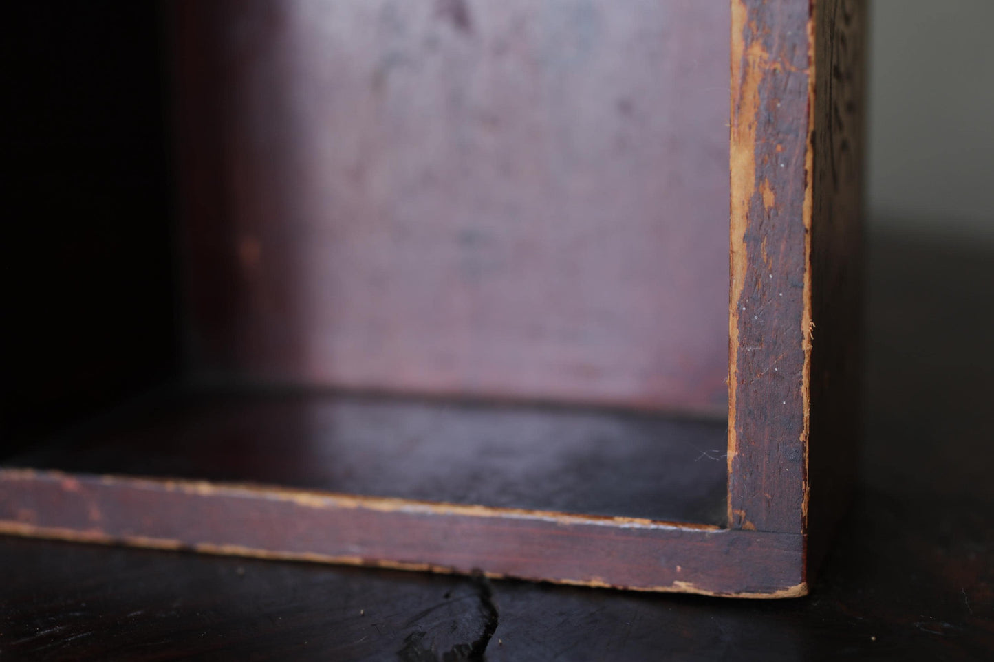 A close-up view of a wooden box with a weathered, aged appearance, suggesting it may be an antique or vintage piece.
