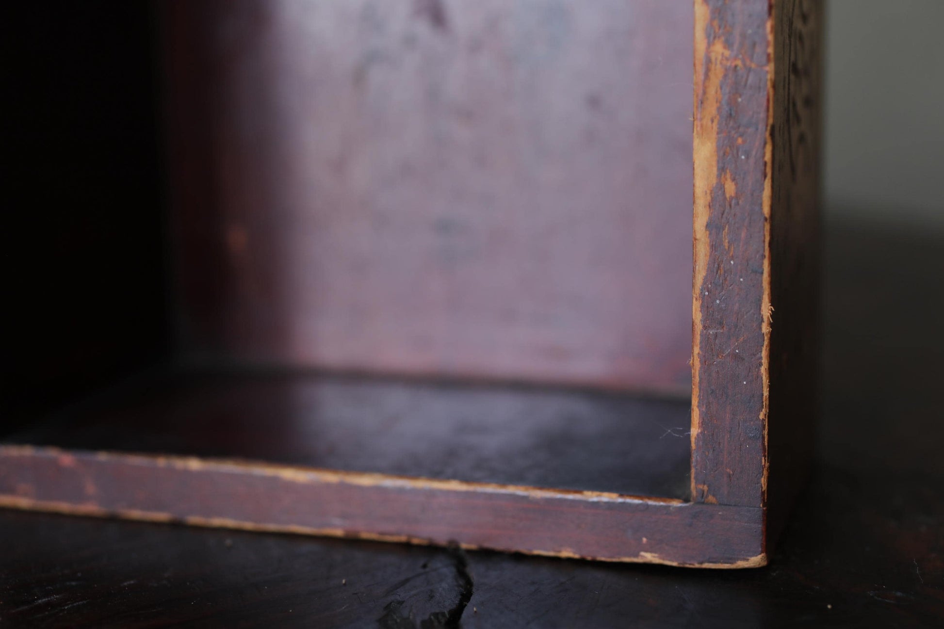 A close-up view of a wooden box with a weathered, aged appearance, suggesting it may be an antique or vintage piece.