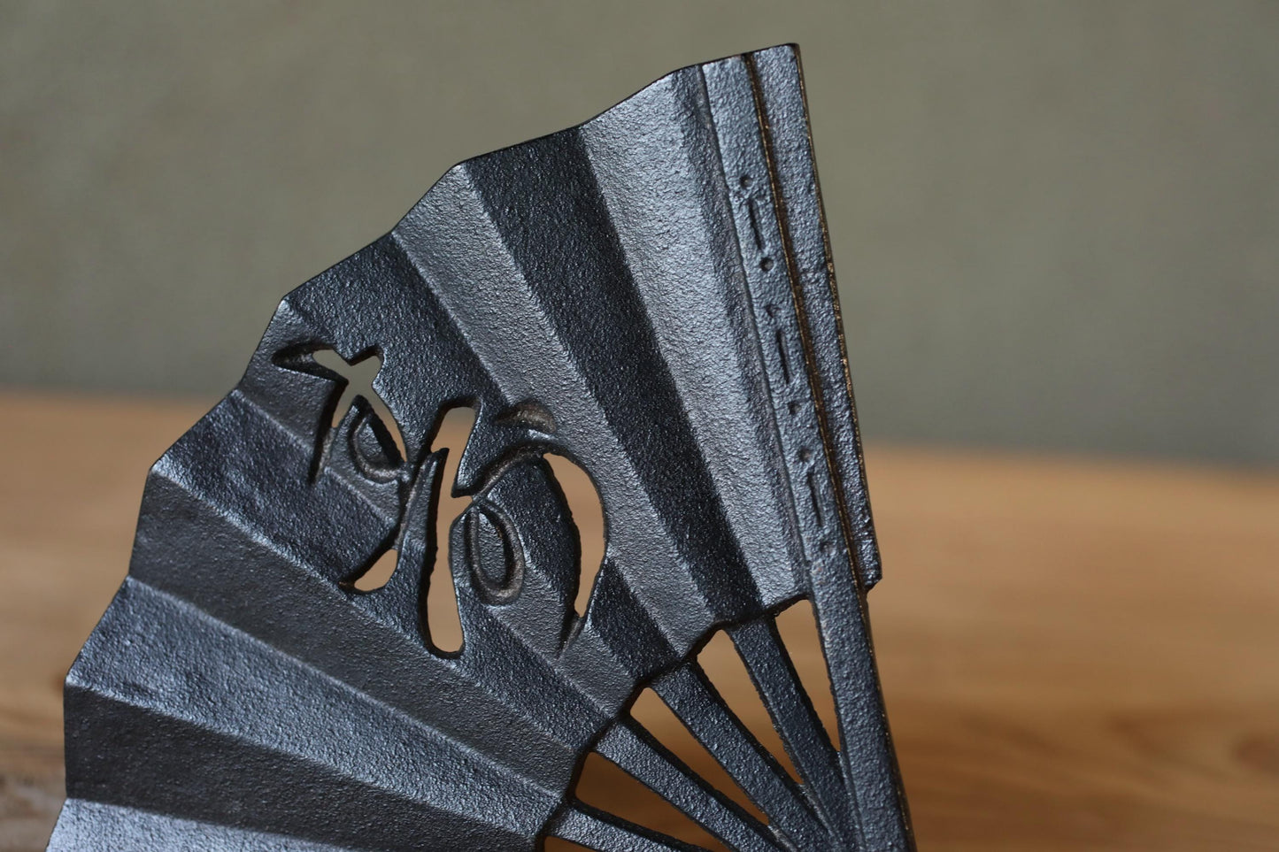 A close-up view of a black metal fan with a decorative design on it.
