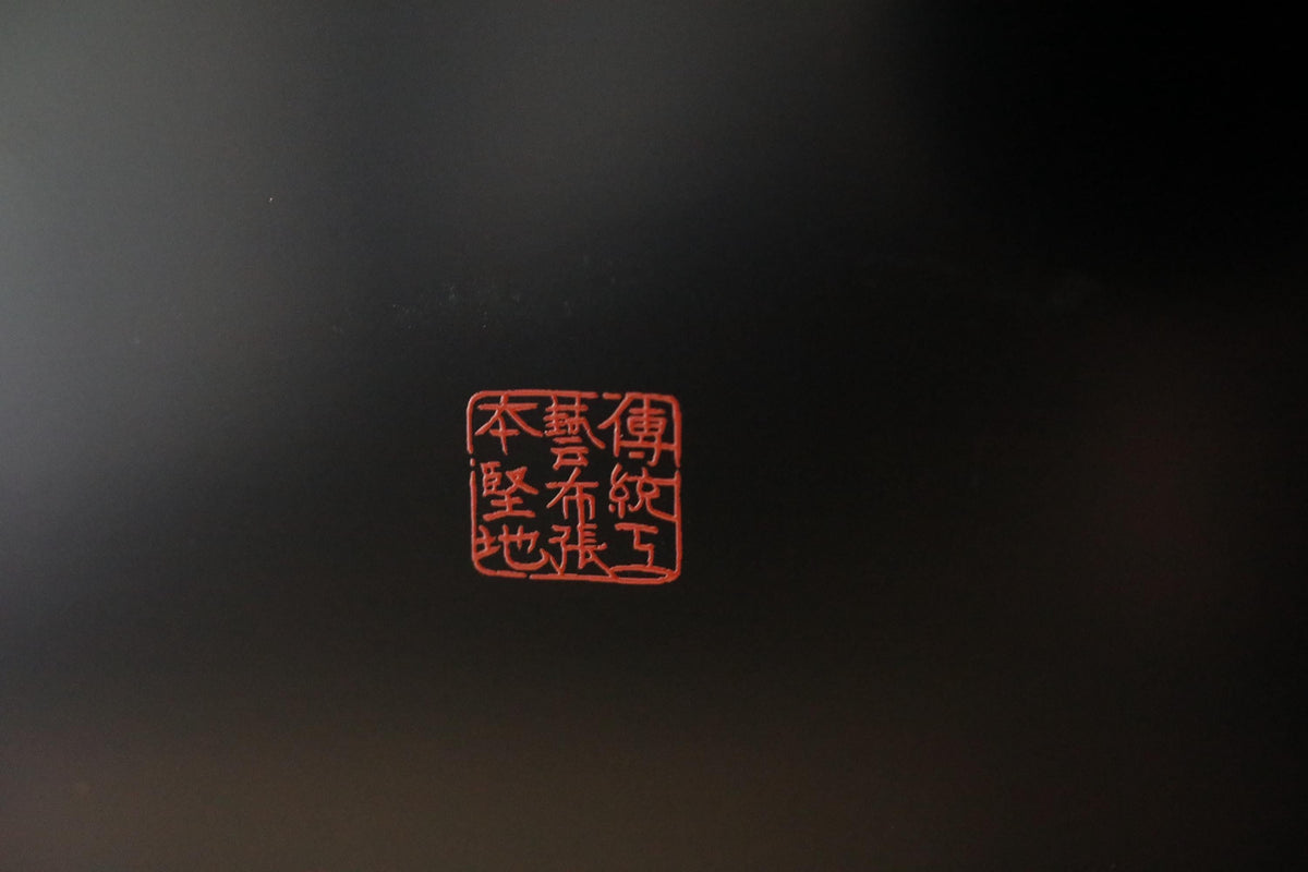 a red square with Chinese characters on it, set against a dark background.