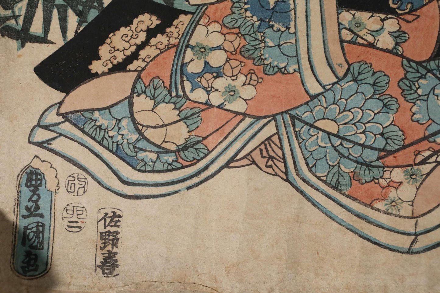 The image is a close-up of a colorful, intricate Japanese-style artwork featuring floral patterns and designs.