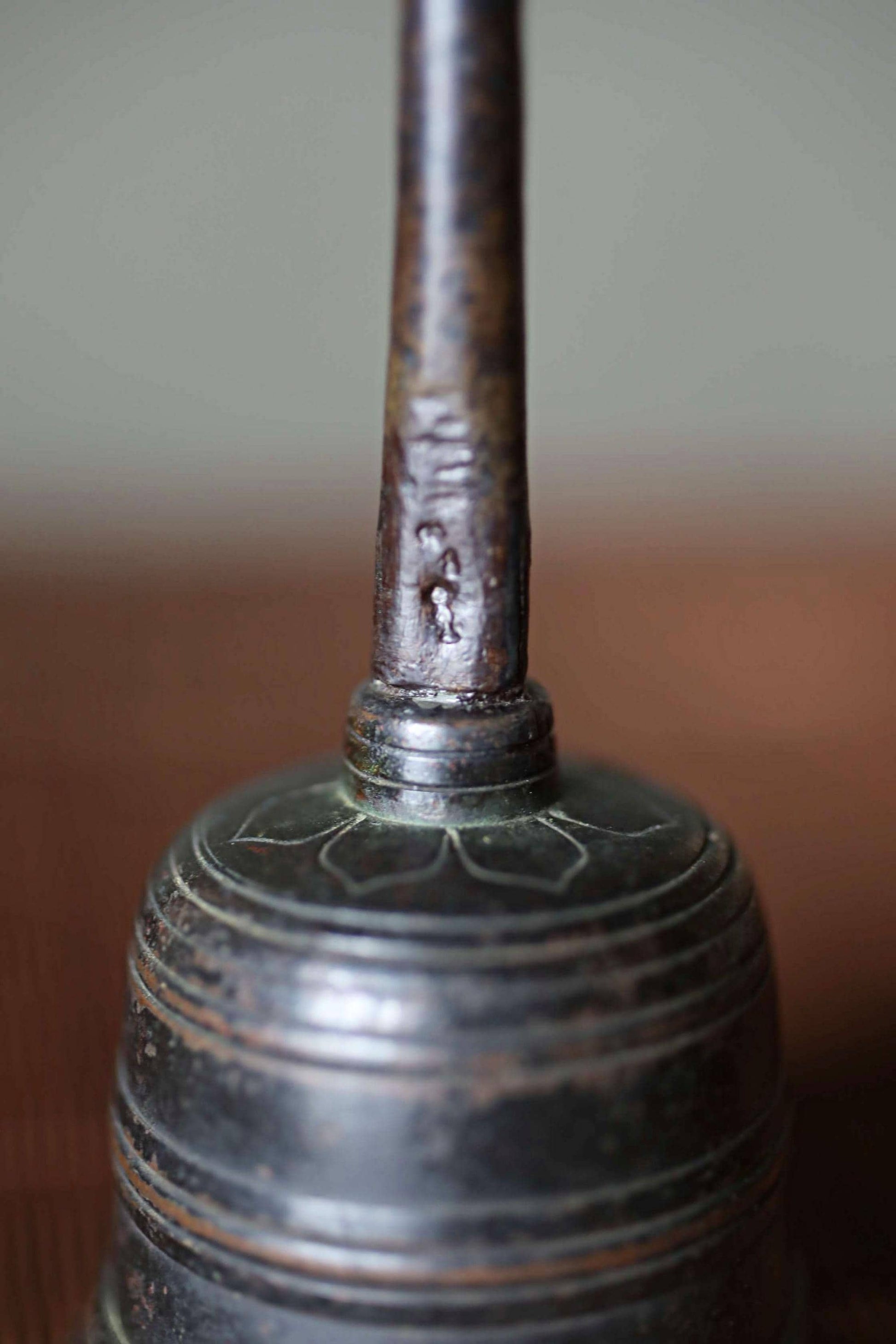 A close-up image of a metal bell with a textured surface and a small hole on the top.