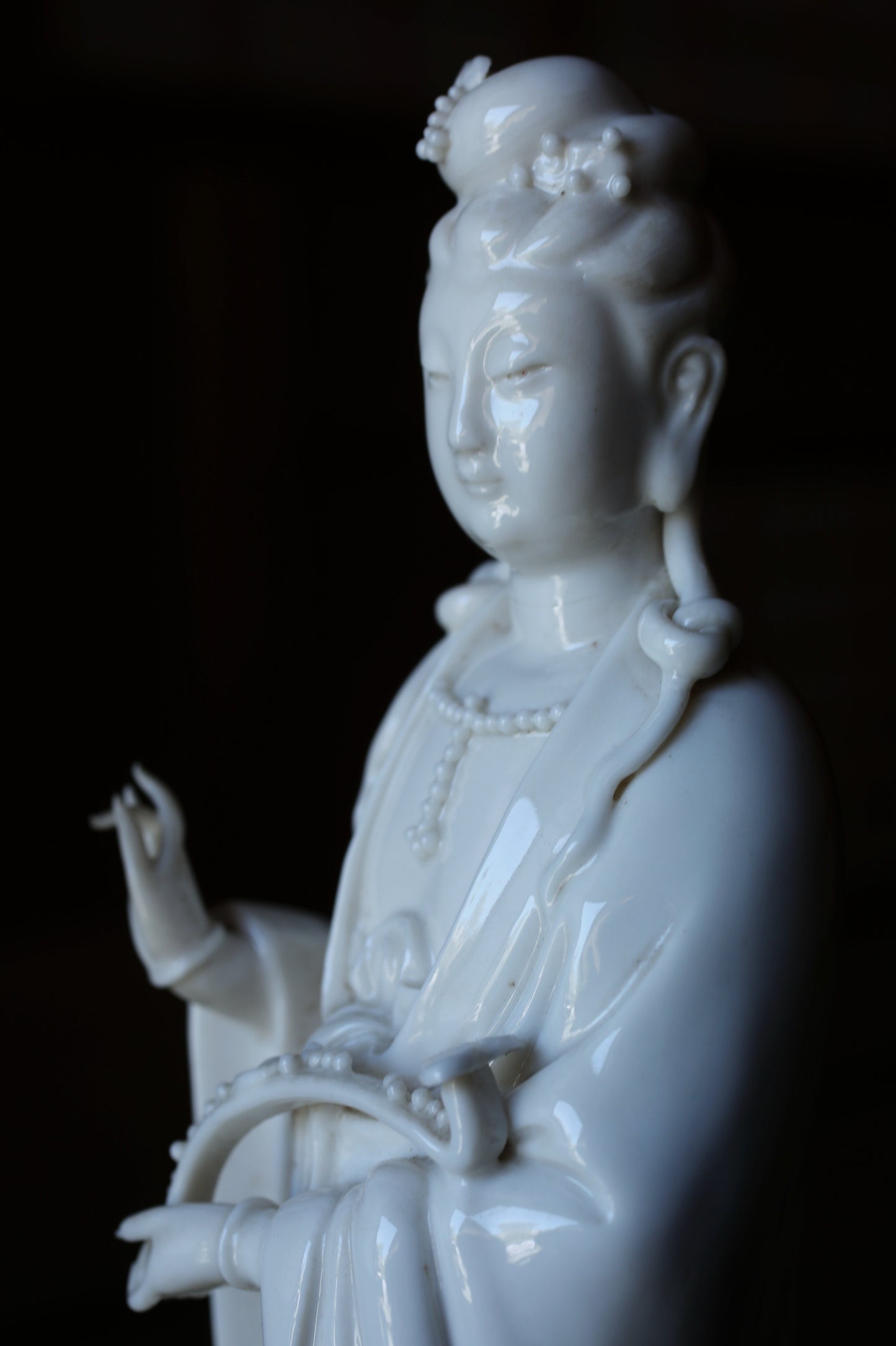 A white porcelain statue of a female deity, possibly a goddess or deity, with an ornate headdress and robe.