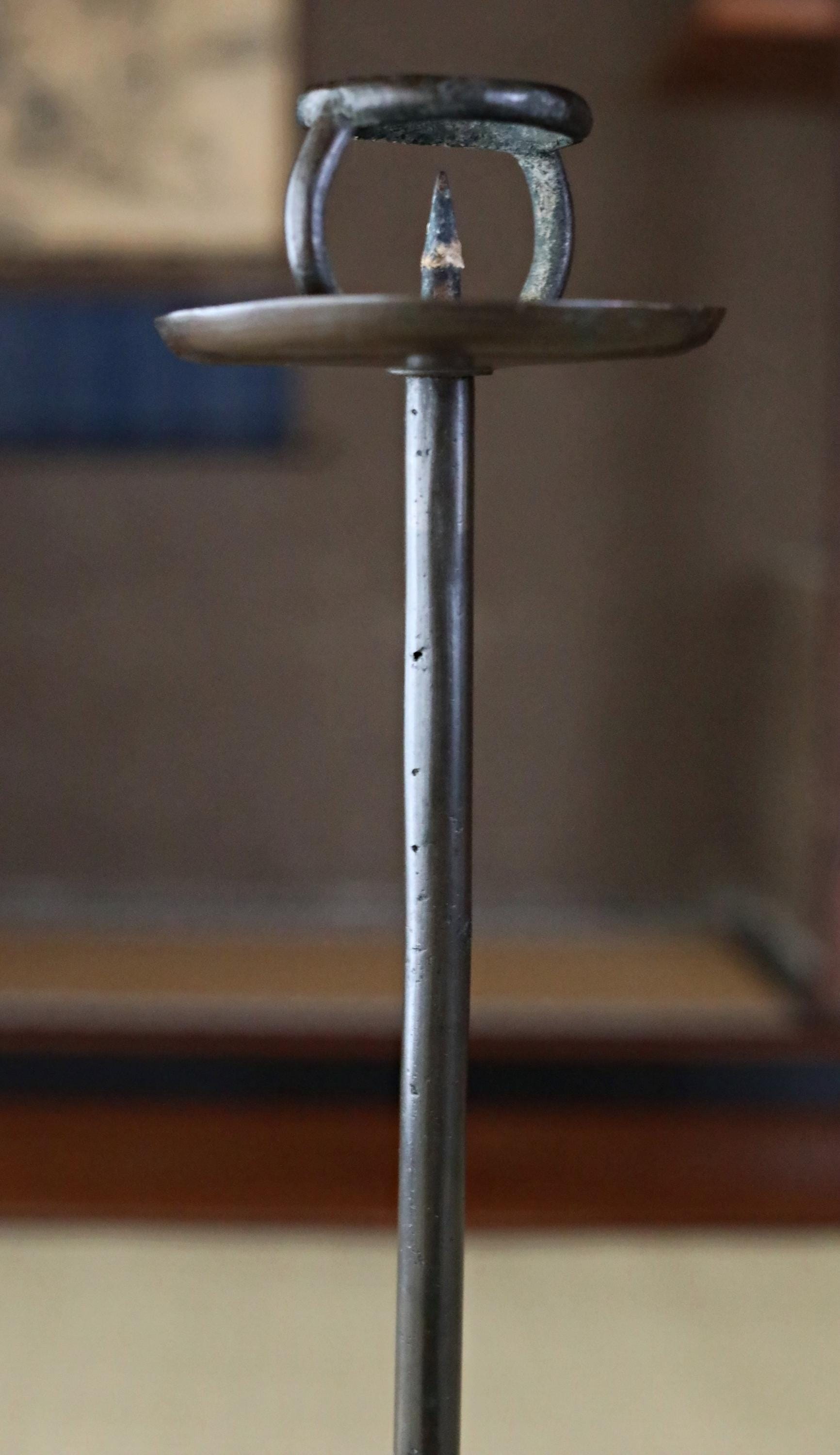 a metal object with a pointed end, standing upright on a surface.