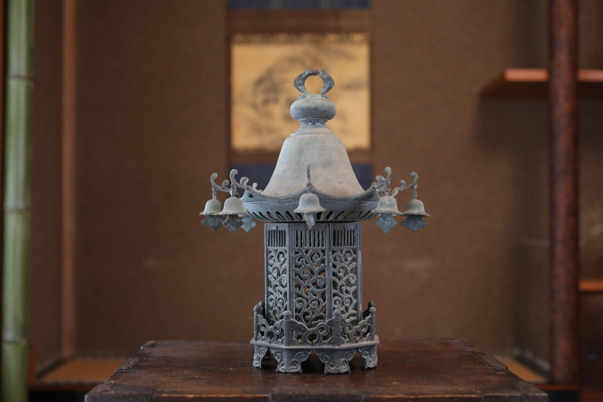 A decorative metal lantern with intricate designs sits on a wooden surface.