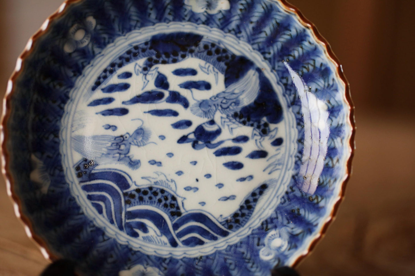 a blue and white plate with a decorative design, including a bird and waves.