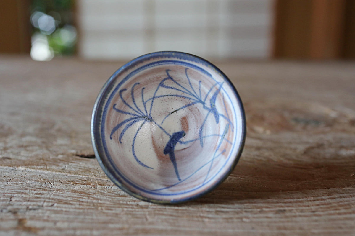A ceramic plate with a blue and white floral design sits on a wooden surface.