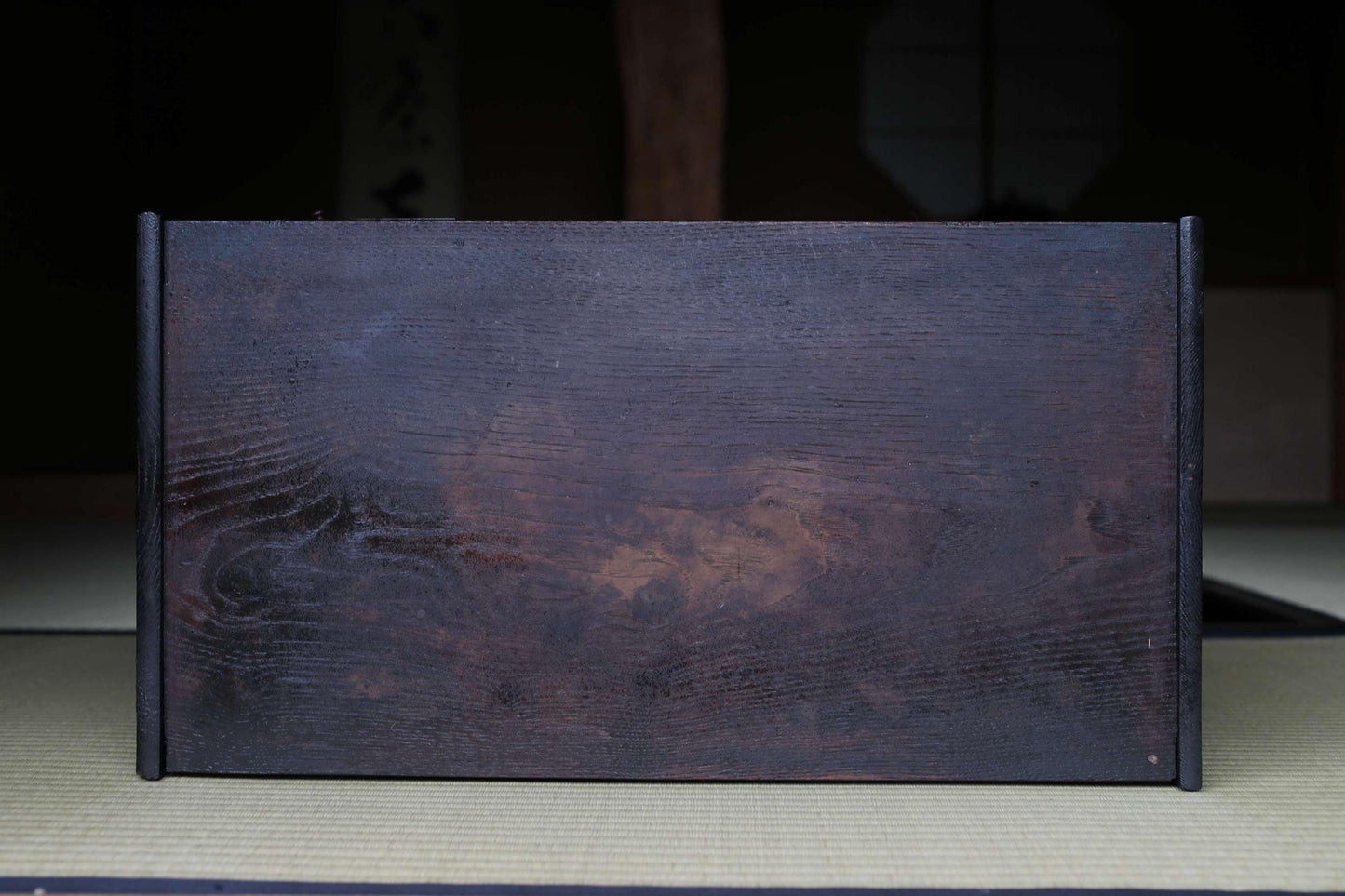 A dark wooden surface with a textured, weathered appearance.