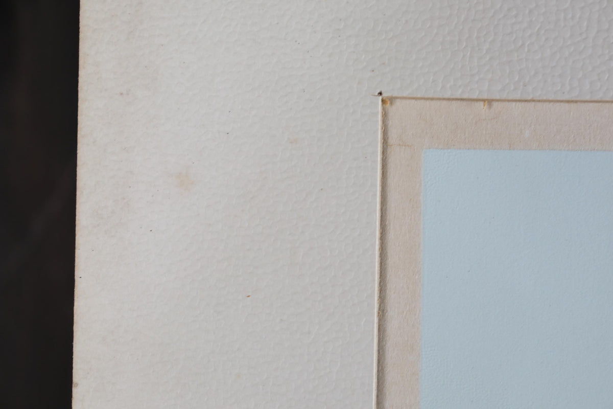a close-up view of a white wall with a small section of a light blue frame visible on the right side.