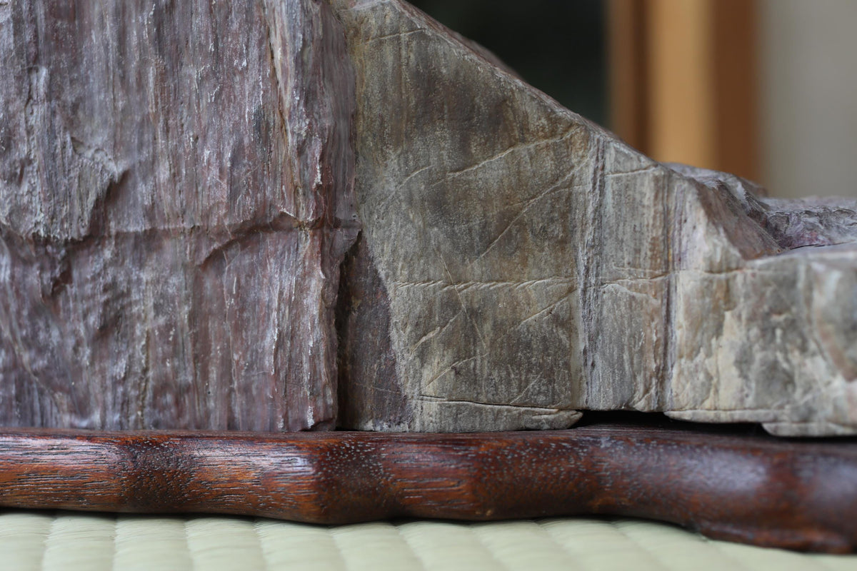 a close-up view of a wooden object with a textured surface, resting on a wooden base.