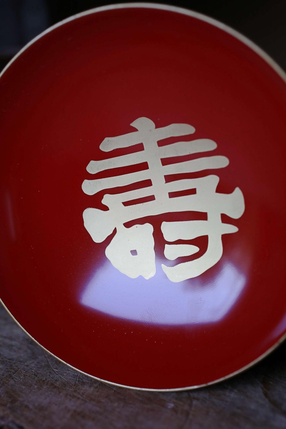 A close-up image of a red plate with a white Chinese character on it.