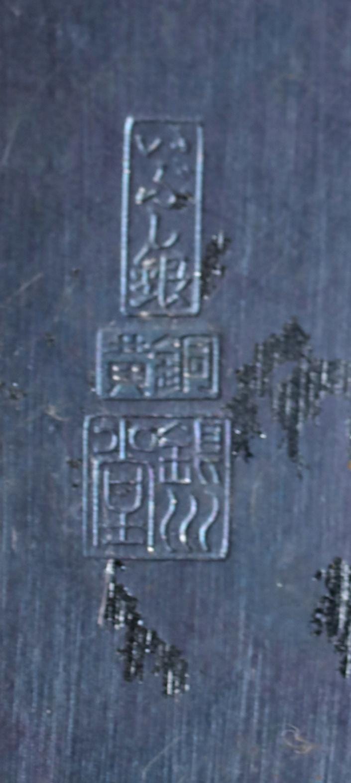 a close-up view of a dark, textured surface with a series of symbols or characters etched into it.