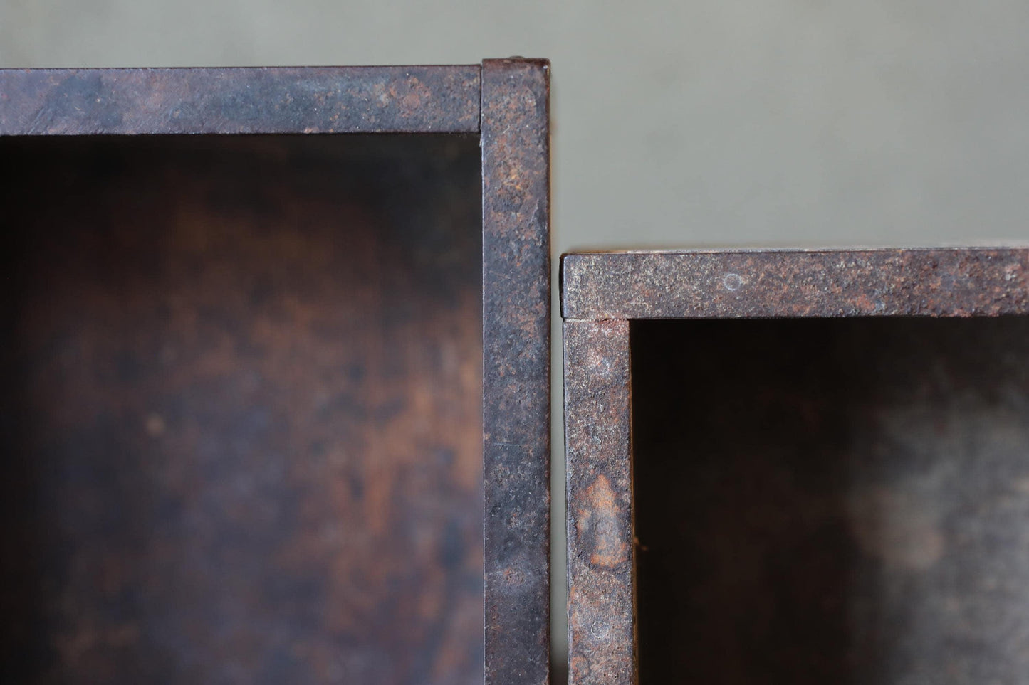 two rusted metal boxes with a weathered, aged appearance.