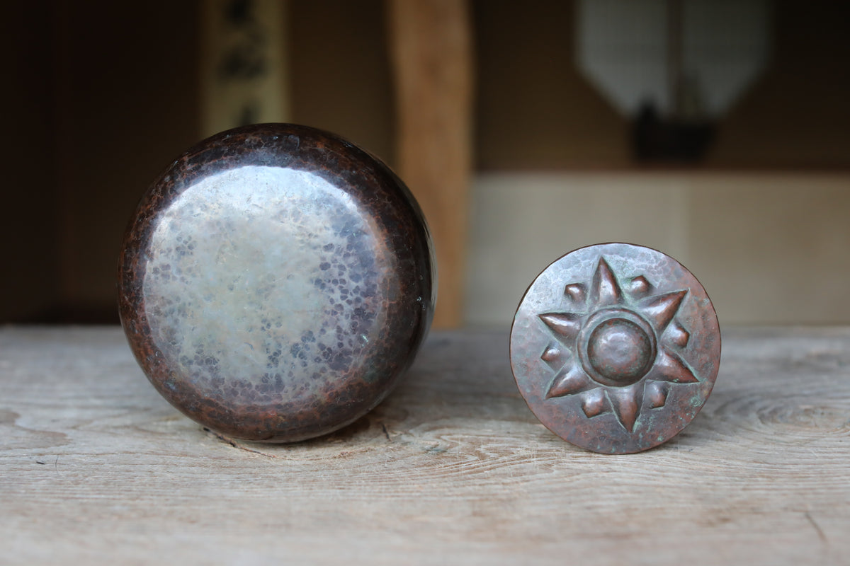 two round metal objects placed on a wooden surface, one larger and one smaller, with a blurred background.