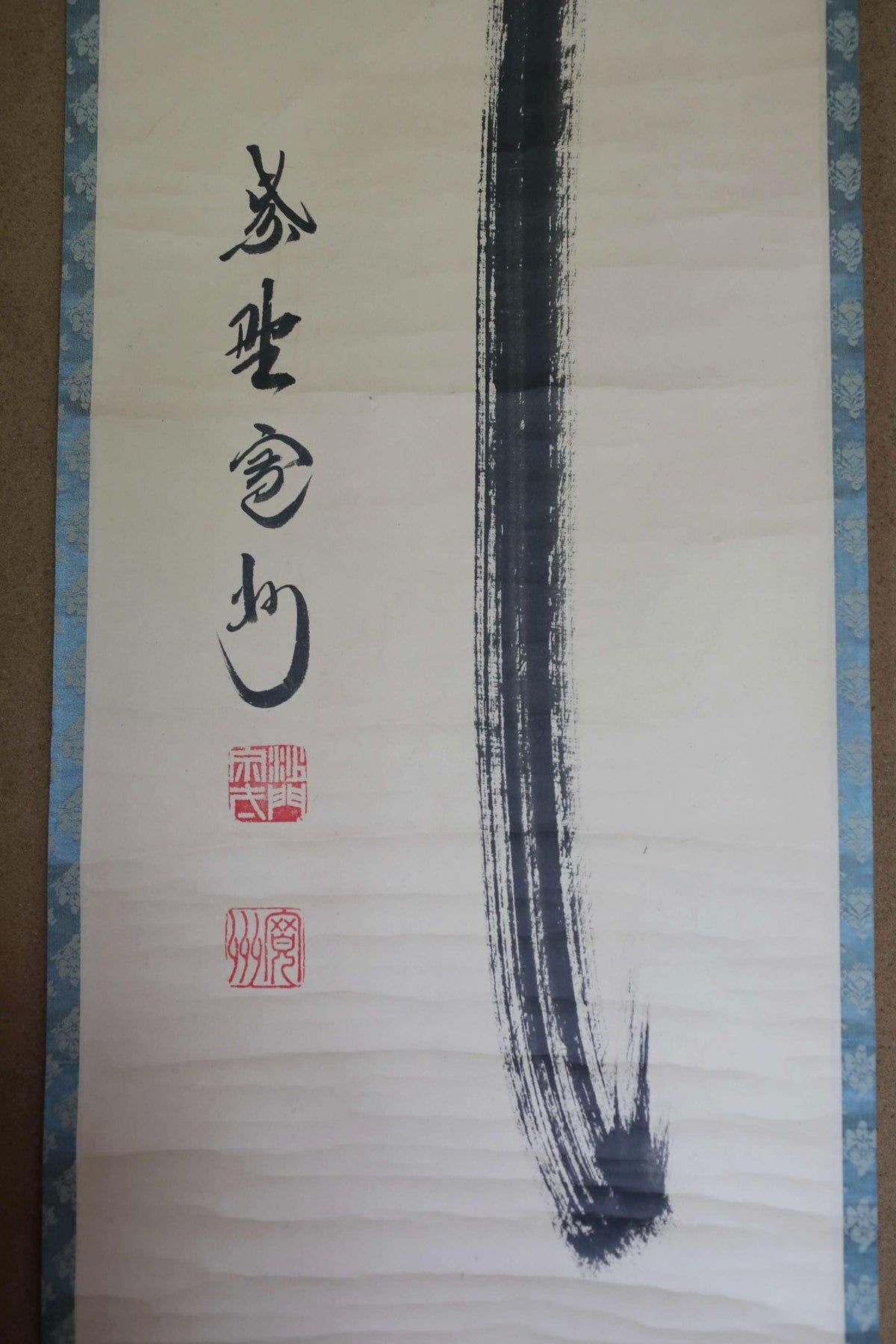 a large, white banner with Chinese characters and a black brush stroke on the right side.