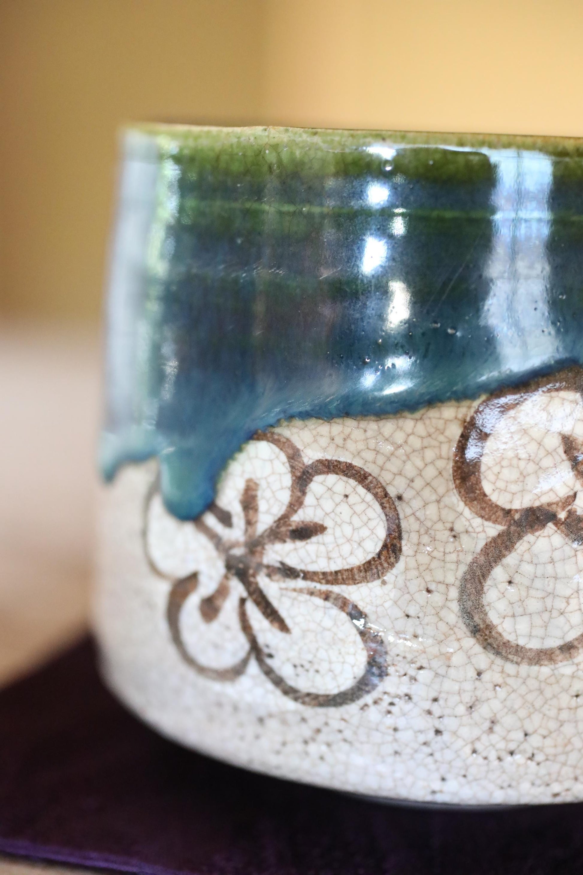 A close-up view of a ceramic piece with a floral design on it, featuring a combination of blue and white colors.