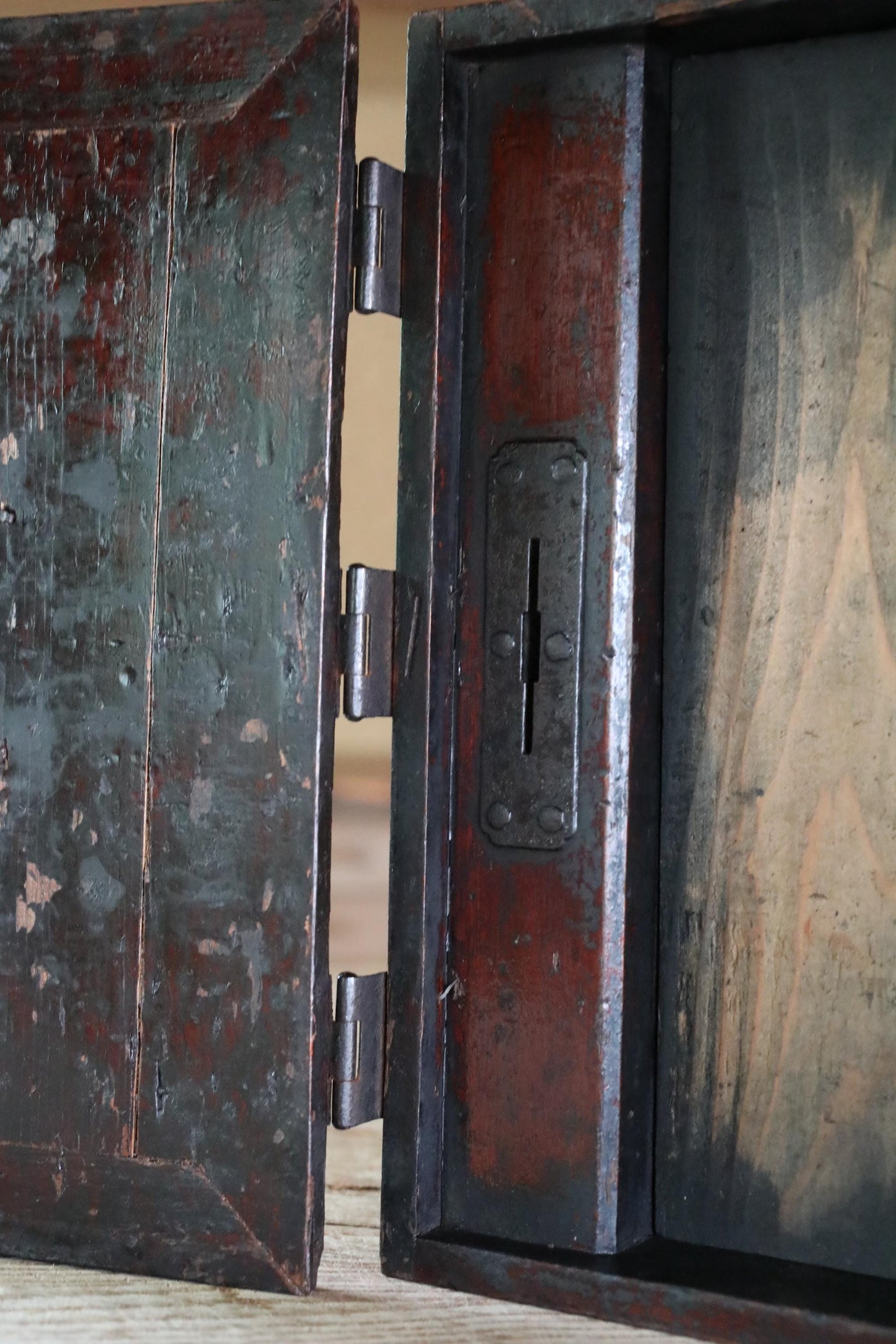 an old, weathered wooden door with a metal latch, suggesting it may be a vintage or antique piece.