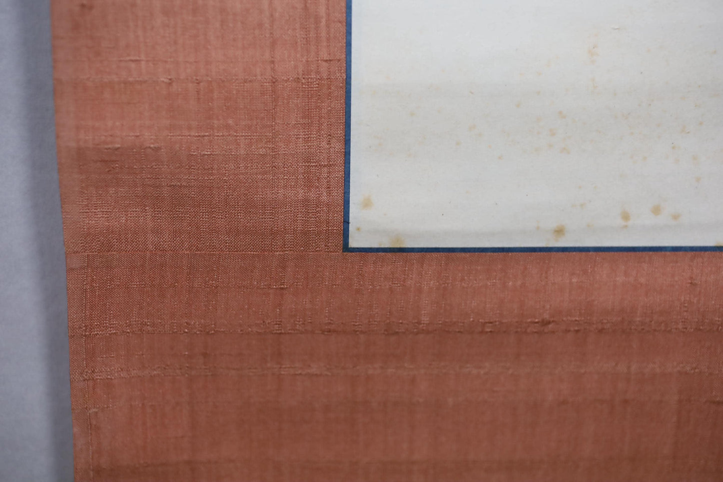 a close-up view of a textured surface, possibly a piece of fabric or paper, with a blue border or frame around it.
