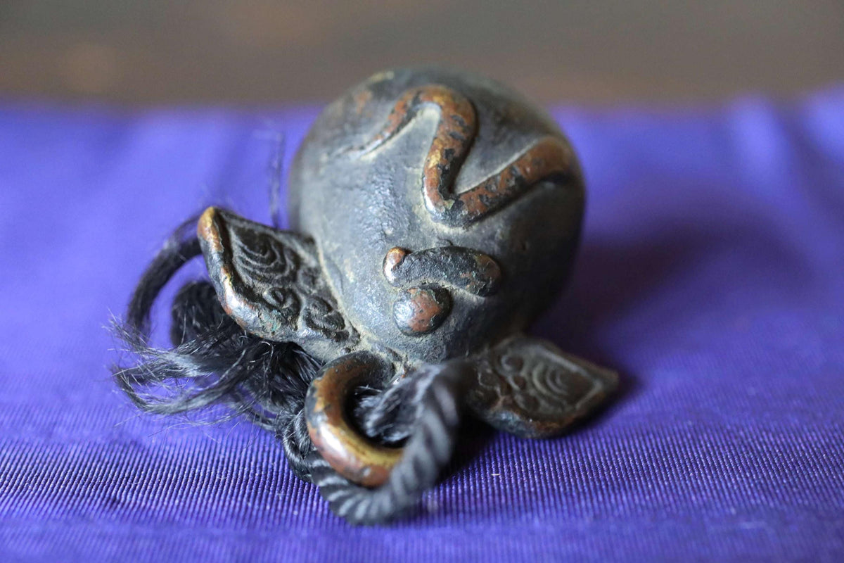 a close-up of a metal object with a textured surface, resting on a purple background.