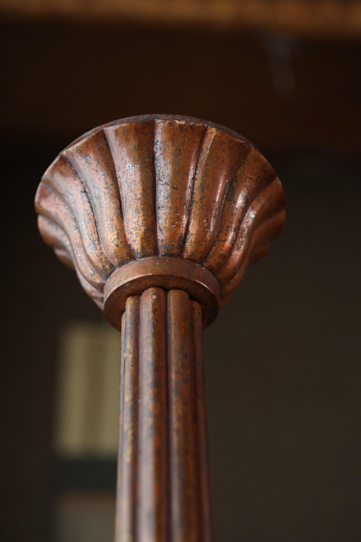 a close-up view of a rusted metal column or pillar, with a textured surface and a slightly weathered appearance.