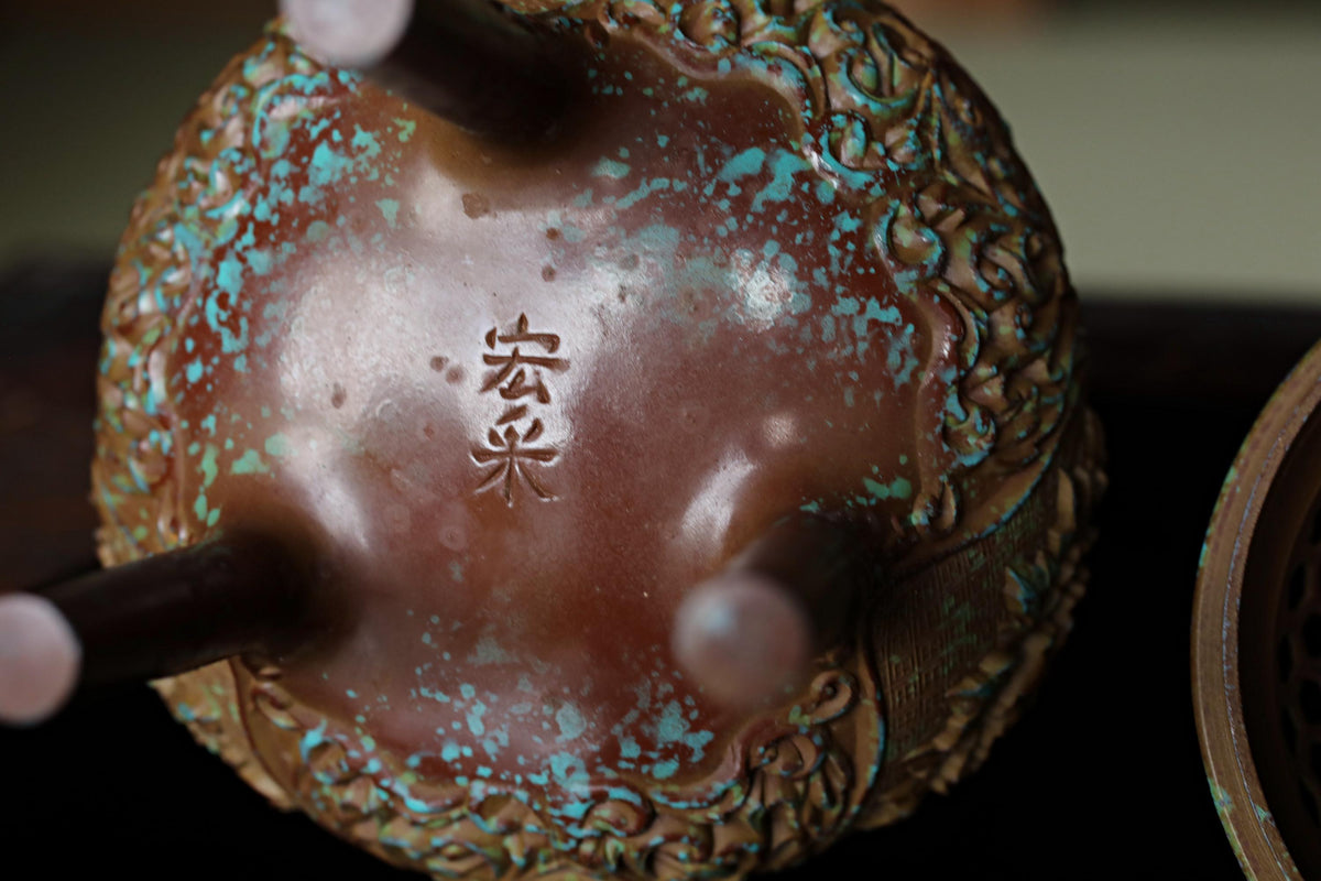 A close-up image of a decorative ceramic object with a floral pattern and a Chinese character on it.
