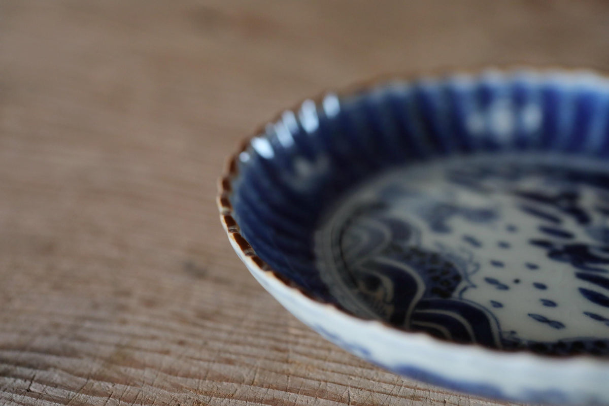 A close-up view of a blue and white porcelain bowl with a decorative pattern on a wooden surface.