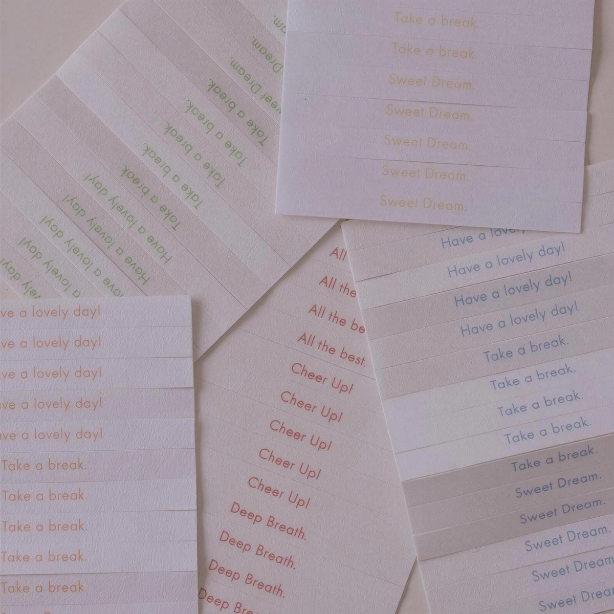 a collection of white paper sheets with various phrases written on them, such as "Take a break", "Have a lovely day!", "Take a break", "Sweet Dream", and "Take a break". The phrases are written in different colors, creating a visually interesting and diverse composition.