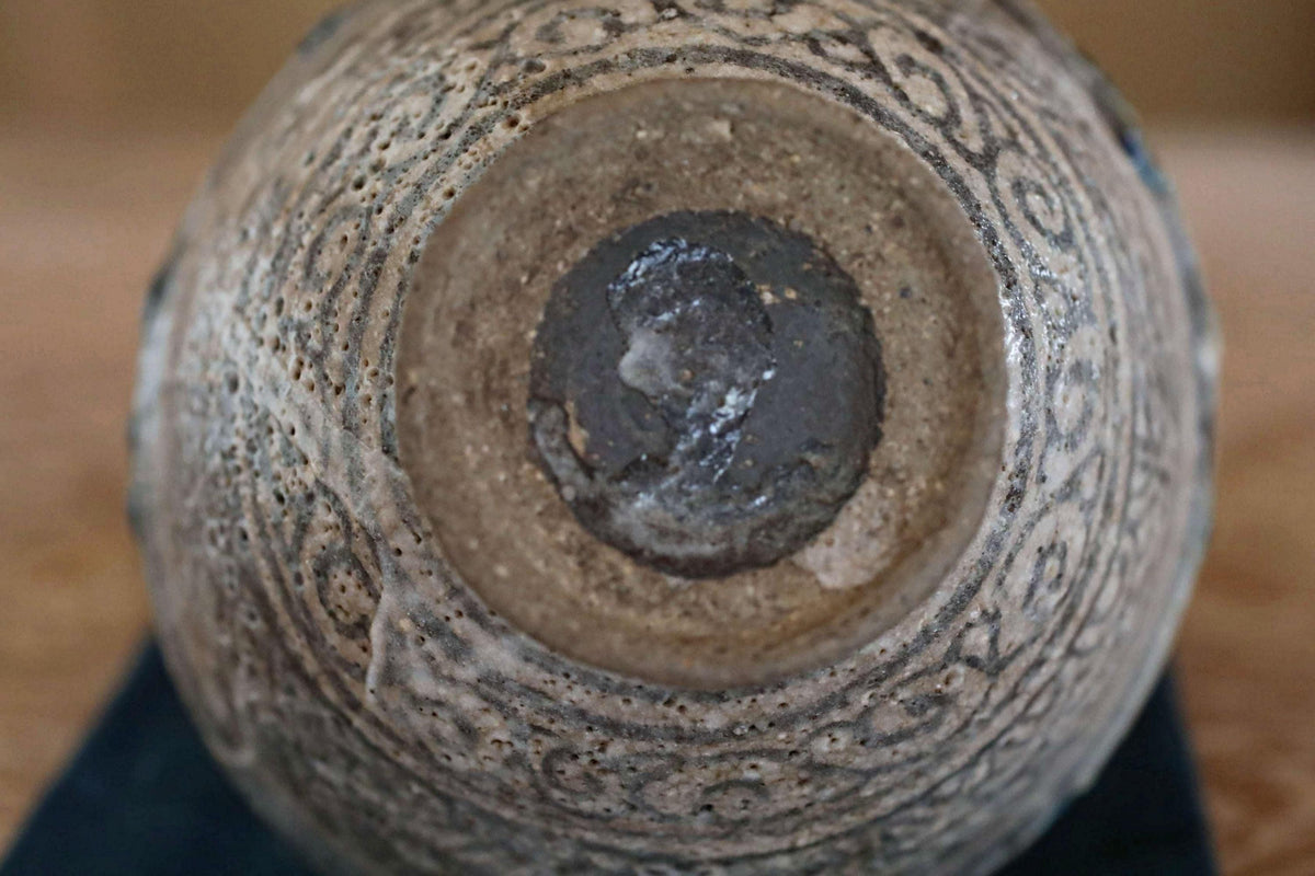 a close-up view of a ceramic vase or bowl with a detailed, intricate design on its surface.