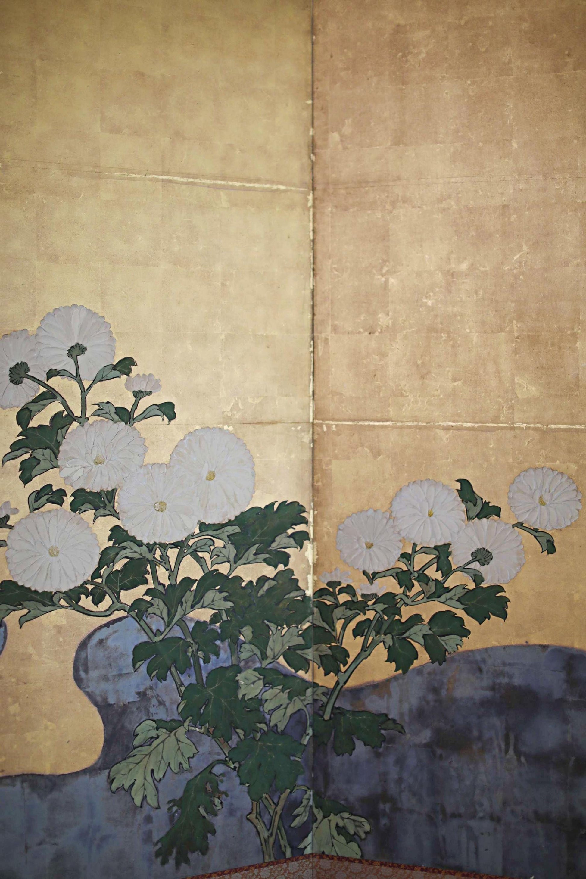 a vibrant floral arrangement with white flowers and green leaves against a beige background.