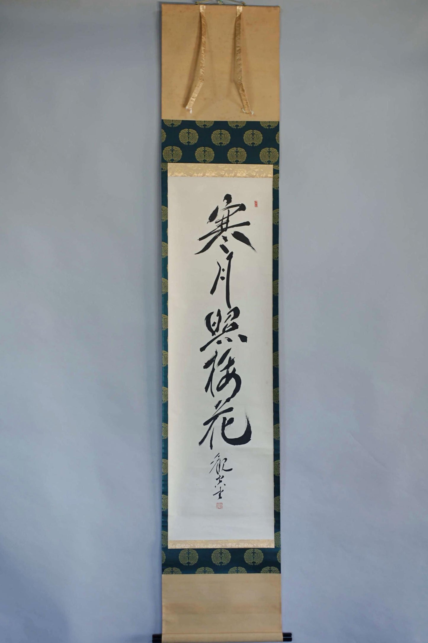 a vertical banner with Chinese characters on it, hanging on a wall.
