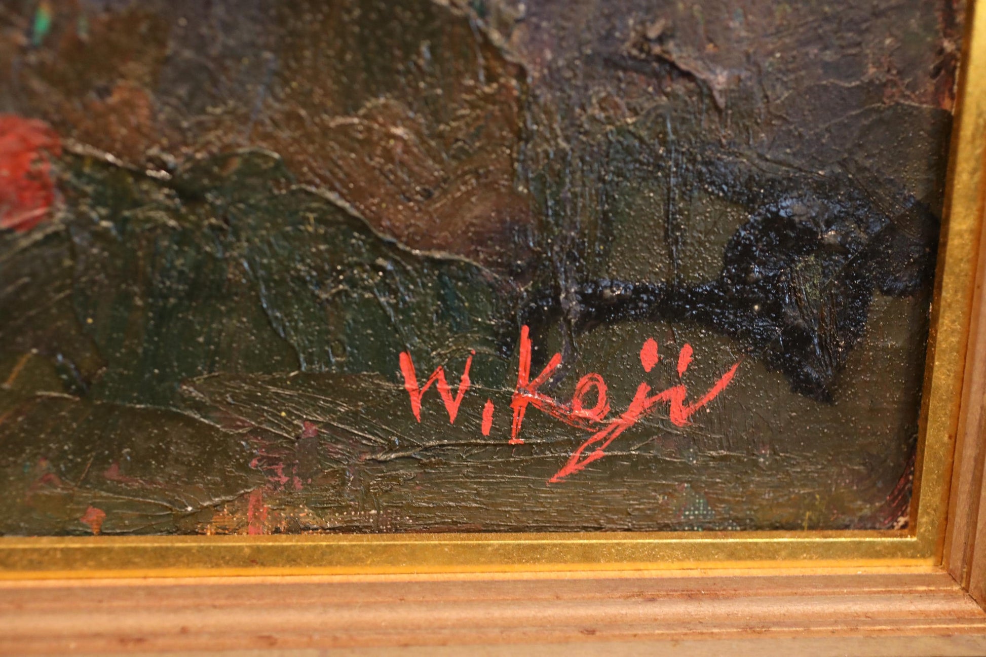 The image is a close-up of a painting with a signature in red ink.