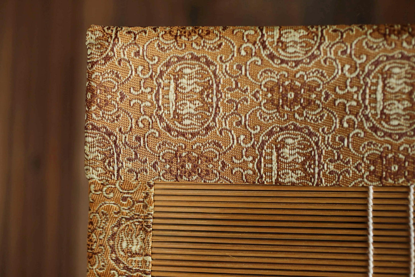 a close-up view of a decorative wooden frame with a patterned design, placed on a wooden surface.