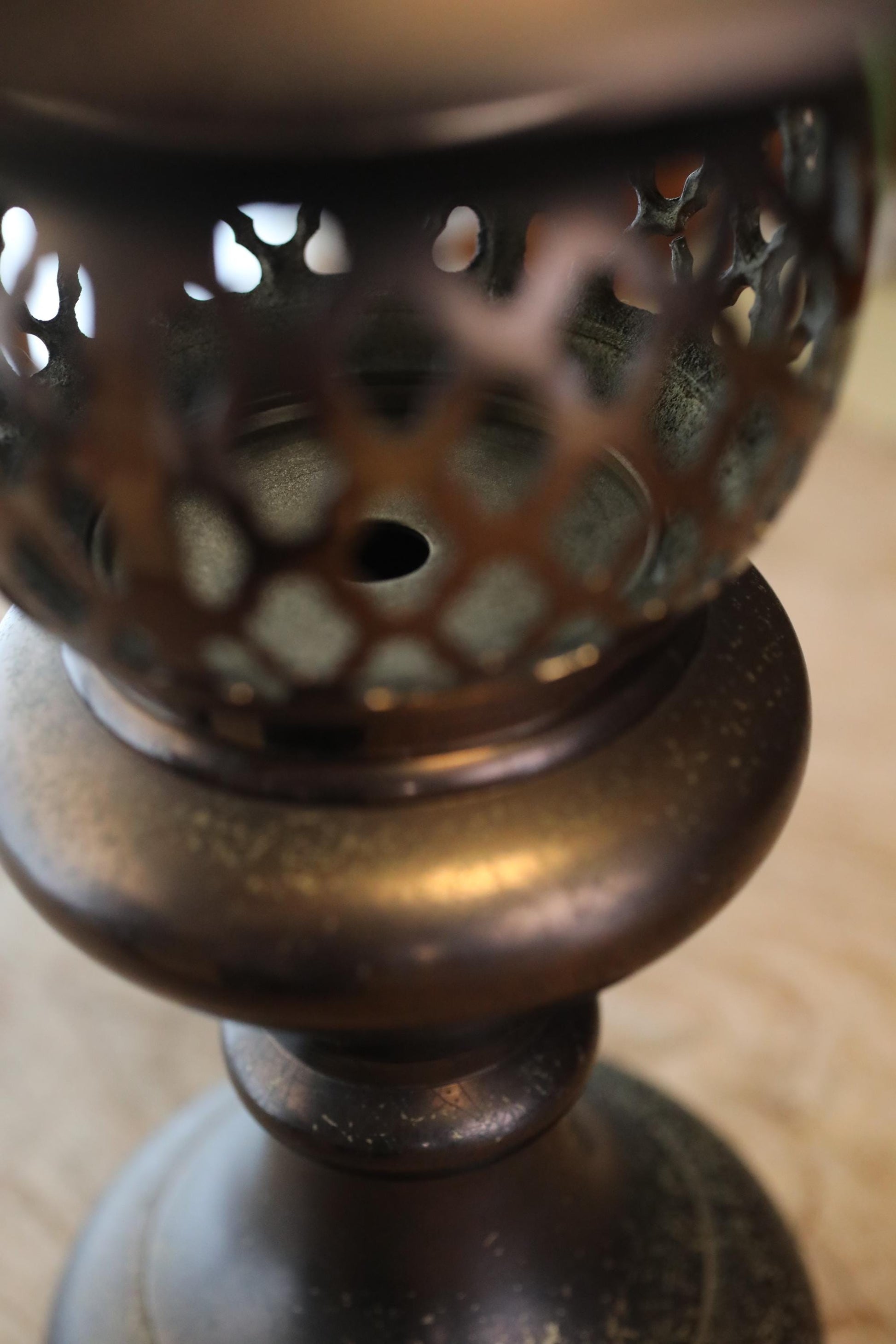 A close-up view of a metal object with a perforated design, giving it a textured and ornate appearance.