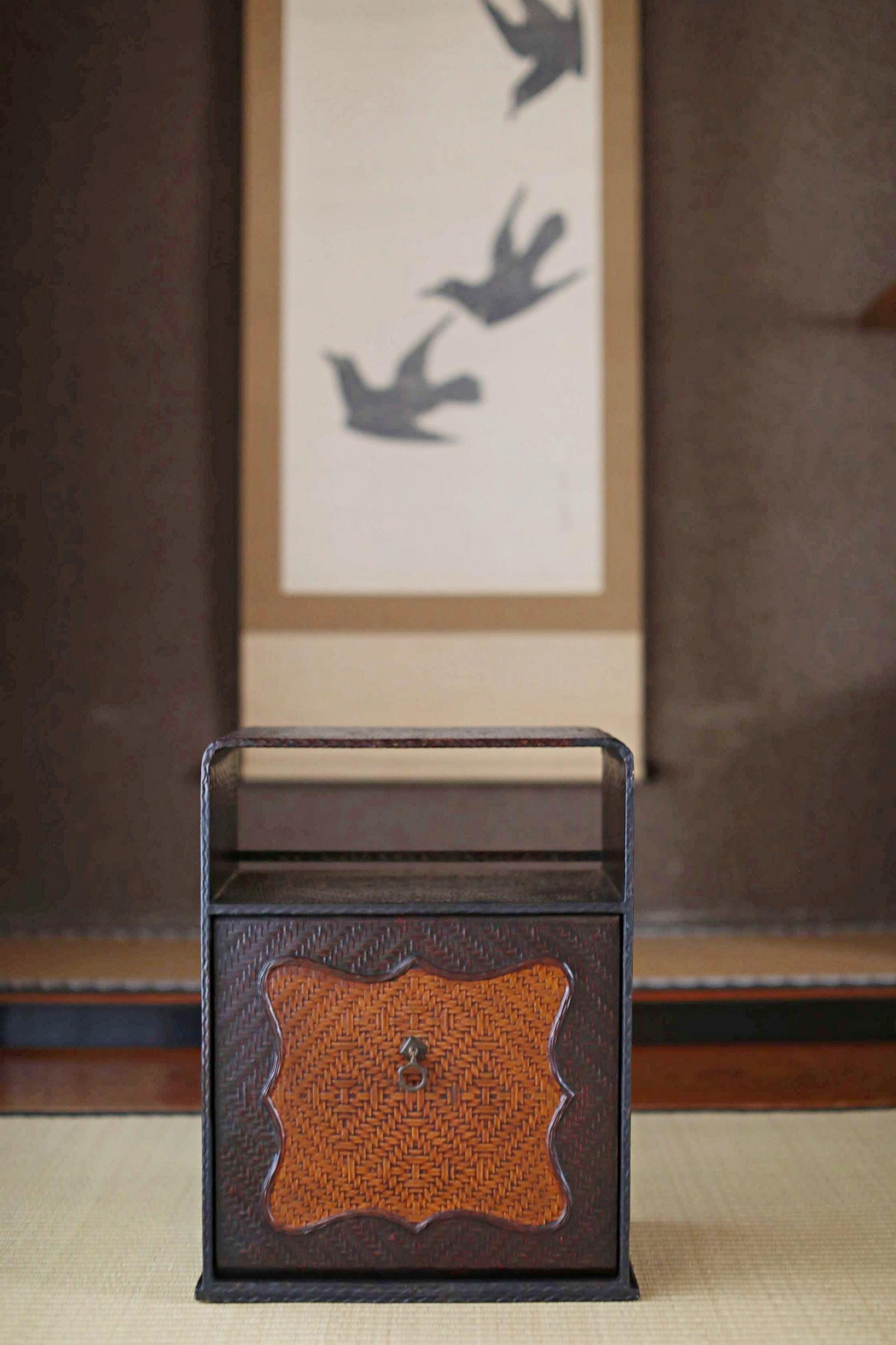 a brown wooden box with a curved lid, placed on a wooden surface.