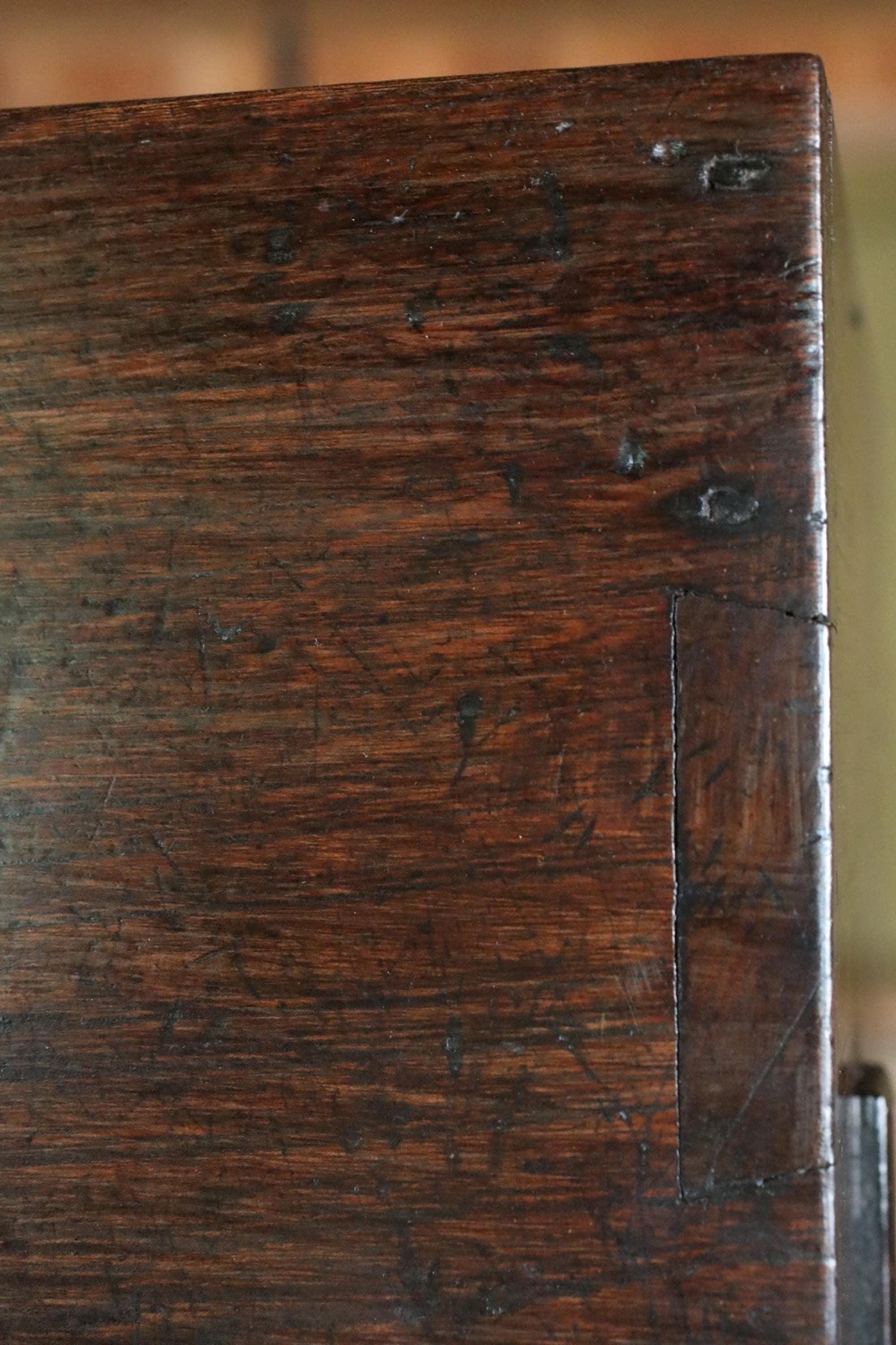 a close-up view of a wooden surface with visible scratches and marks, suggesting it has been used or has been exposed to the elements over time.