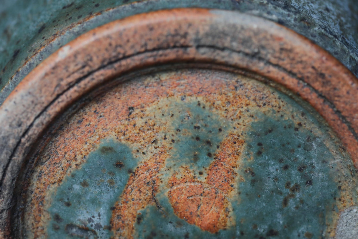 a close-up view of a rusted metal surface with a mix of orange, green, and blue colors.