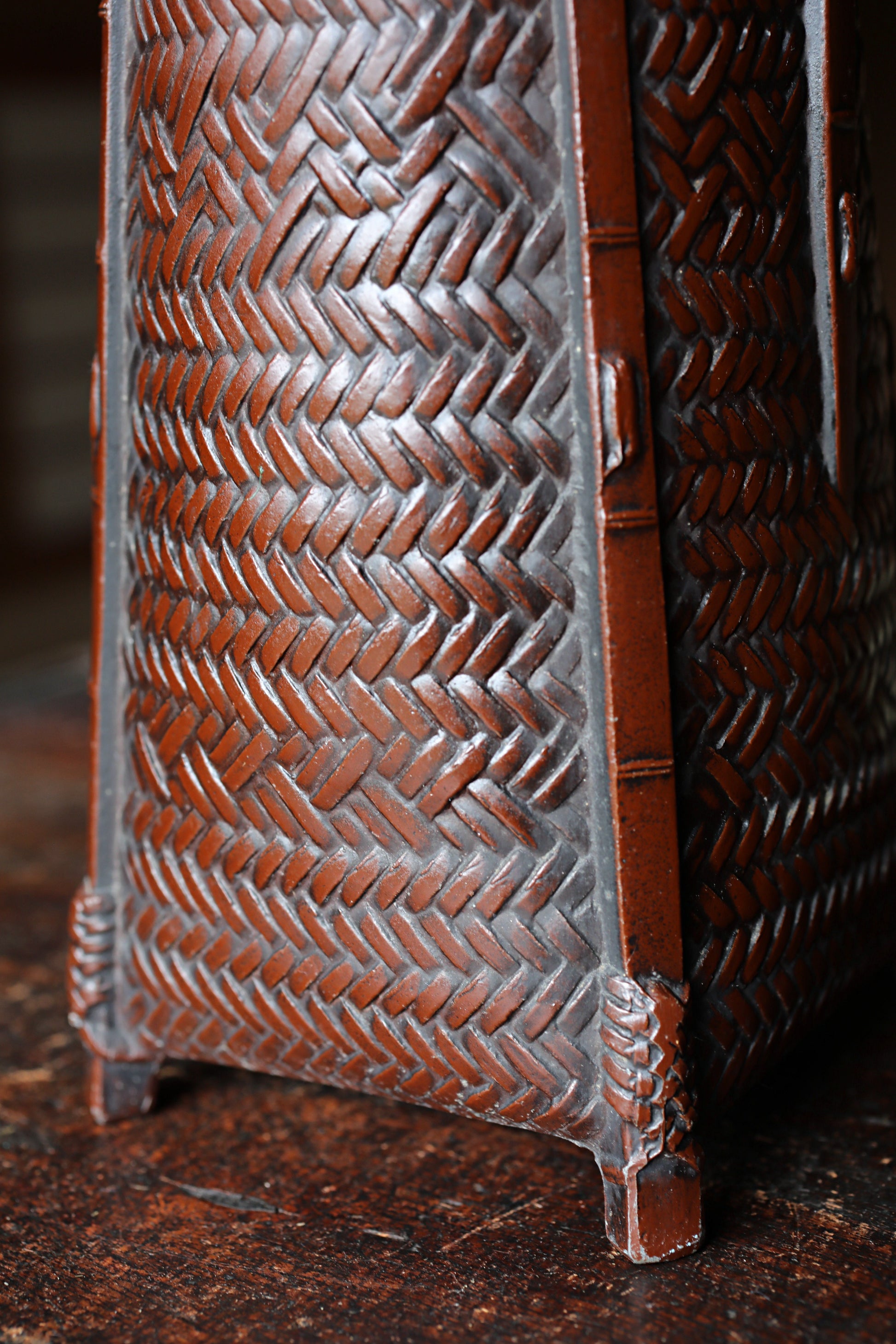 A close-up view of a woven basket or container with a textured, brown-colored surface.