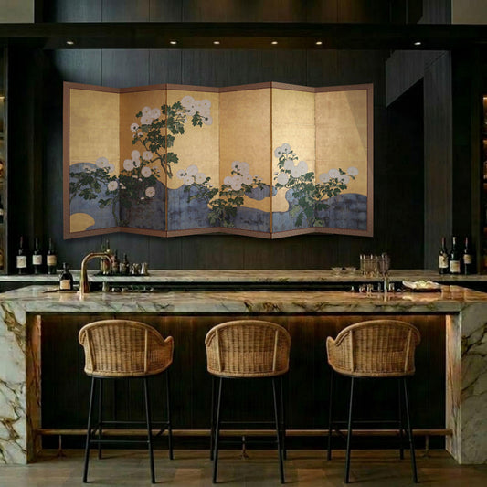 a modern bar area with a large, colorful painting of flowers on the wall behind the bar. The bar is equipped with three wicker barstools and a marble countertop.