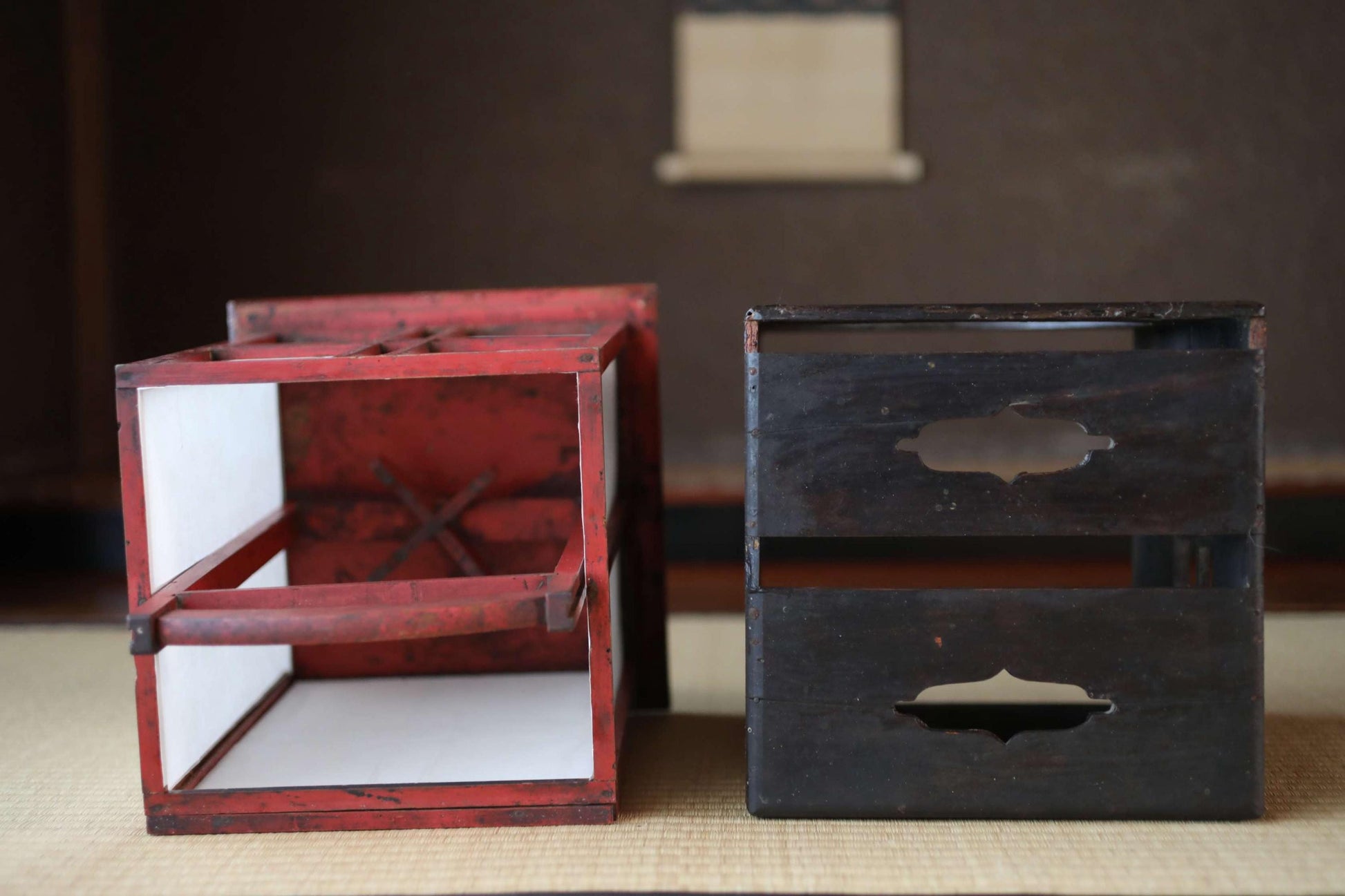 two wooden crates, one red and one black, placed side by side on a surface.
