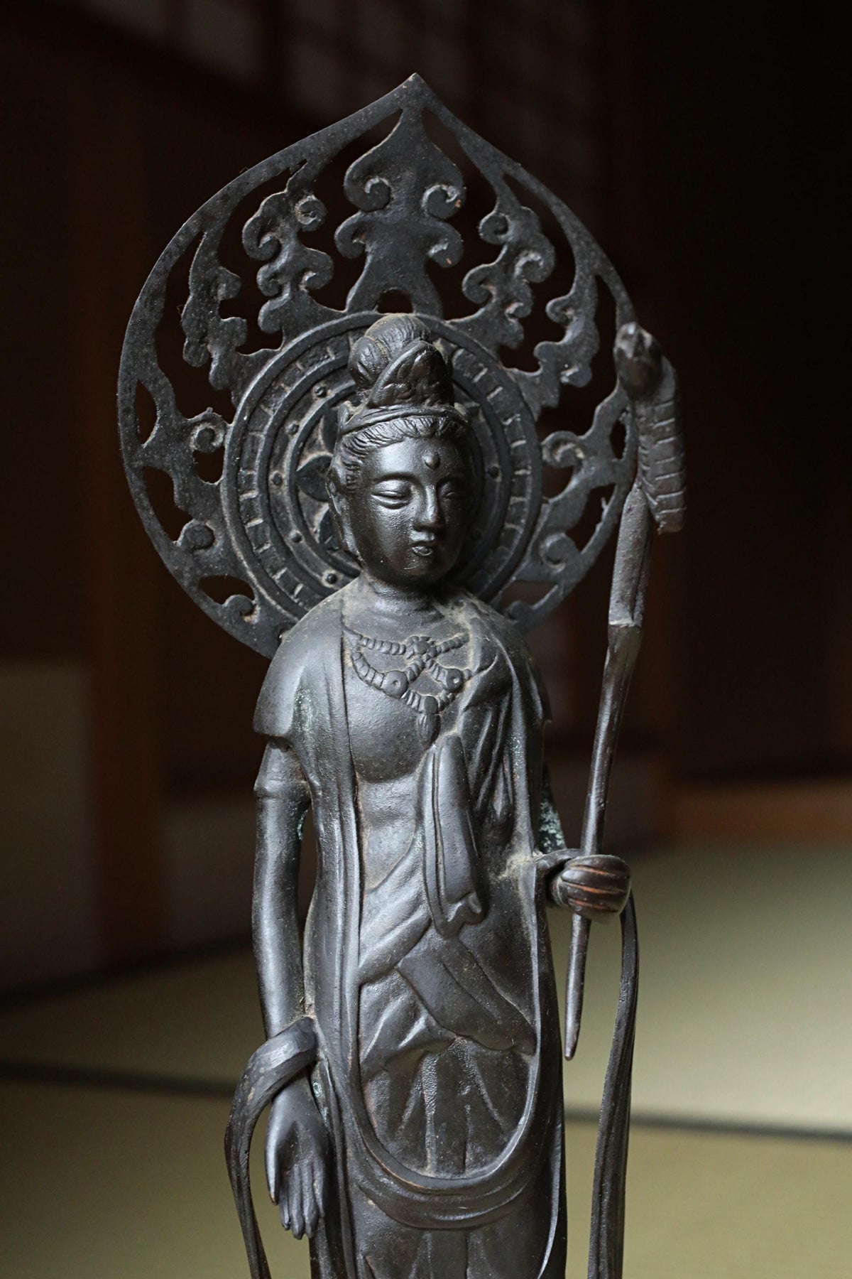 A bronze statue of a Buddhist deity, likely a Buddha, with intricate designs and a serene expression.
