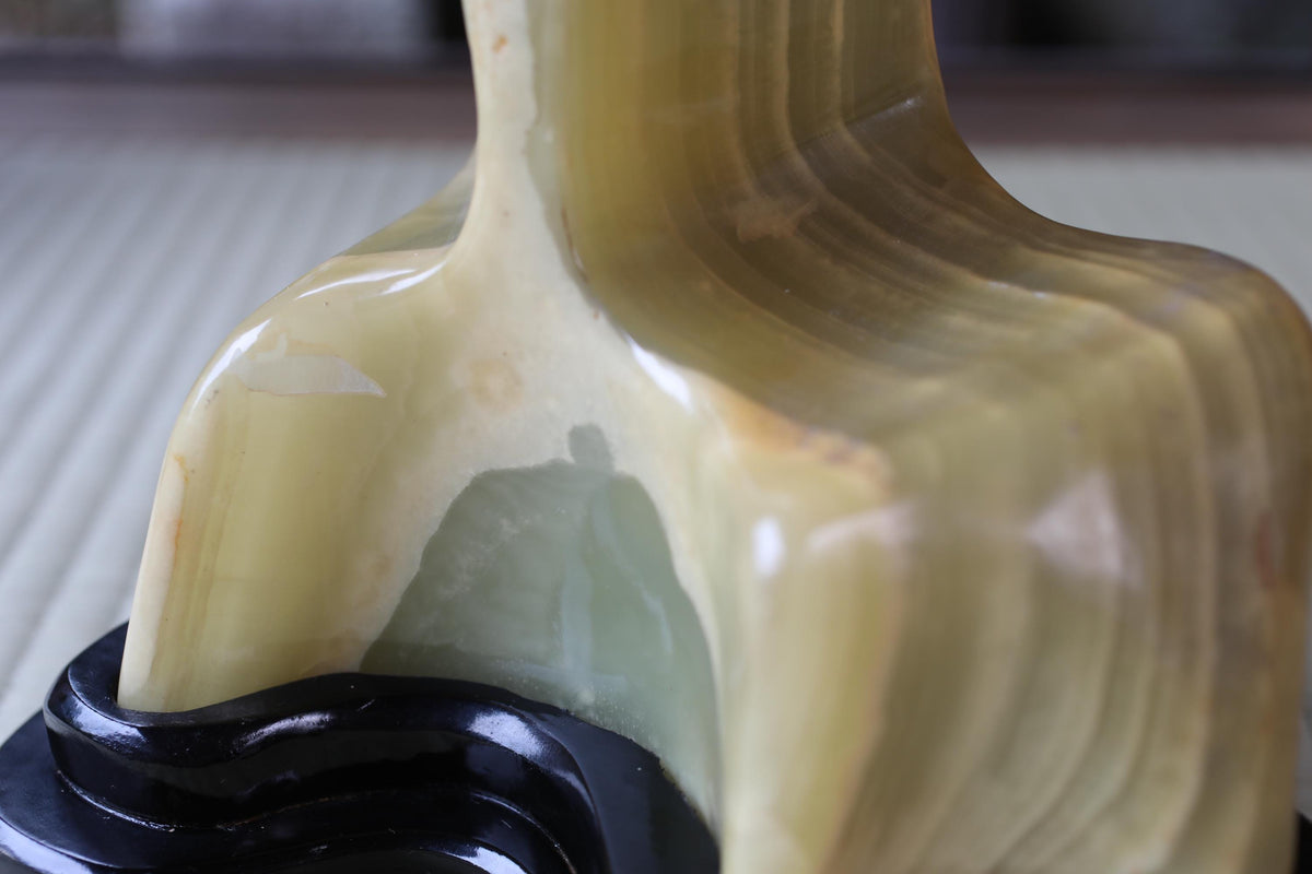 a close-up view of a yellowish-green, textured surface, possibly a piece of pottery or a sculpture.
