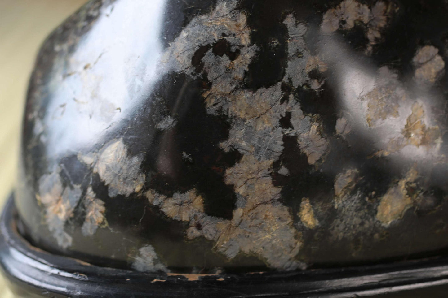 a close-up view of a black, textured surface with a mix of dark and light areas, possibly resembling a piece of metal or a textured fabric.